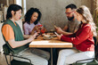 © Maria Vitkovska - Young people ignoring each other while using smartphones at cafe
