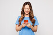 © ViDi Studio - Young smiling happy Caucasian woman she wears blue t-shirt casual clothes hold in hand use mobile cell phone typing message isolated on plain solid white background studio portrait. Lifestyle concept.