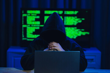 Hackers are in a dark room, wearing hats and warts, hacking government data servers to steal data and infect the systems with viruses, using laptops and multiple computer monitors to display the data.