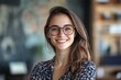 © imageSTOCK - Confident smiling woman in glasses standing in a cozy modern cafe with greenery and wooden decor during daytime