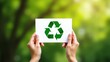 © Zone - Recycling symbol on a piece of paper held by hands.