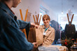 © Big Shot Theory - Friendly Retail Interaction Customer Happily Receiving a Package in the Store