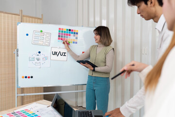 Wall Mural - ux ui presentation and team collaboration. a team member emphasizing design concepts on a whiteboard