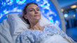 © Maksym - MRI machine scanning patient in sterile room, blue ambient lights reflect medical precision.