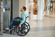 © Serhii - Customer exiting elevator in wheelchair at shopping mall