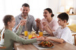 © New Africa - Family praying together before dinner at table indoors