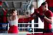 © New Africa - Woman in protective gloves having boxing practice with her coach at training center