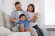 © New Africa - Cute little boy and his parents on sofa at home. Lovely family