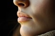 © Alynsyd - Close-Up of a Woman's Lips and Skin Texture Against Dark Background