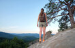 © bilanol - Hiker woman walking on mountain footpath enjoying evening nature. Lonely female traveler traversing wilderness trail. Healthy lifestyle concept