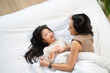 © winnievinzence - Top view of Asian mother and daughter cuddle and talking on bed. Family enjoy playing and spending time together at home