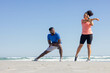 © Wavebreak Media - Couple stretching on beach, enjoying outdoor workout and healthy lifestyle