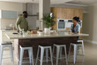 © Wavebreak Media - African American couple chatting in modern kitchen while preparing meal together