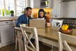 © Wavebreak Media - Mature Asian couple reviewing documents together at kitchen table with laptop