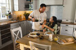 © Wavebreak Media - Mature Asian couple enjoying wine and dinner together in cozy kitchen setting