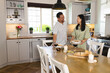 © Wavebreak Media - Asian couple enjoying conversation while preparing meal together in cozy kitchen
