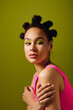© Bliss - Young woman showcases vibrant fashion with playful hairstyle against a bold green background