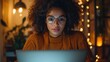 © Adobe - Focused woman works on laptop at night, warm lighting