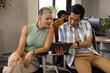 © Wavebreak Media - Collaborating Diverse coworkers reviewing tablet in open-plan office, with chairs and plants