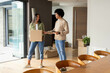 © Wavebreak Media - Standing diverse couple unpacking moving boxes in modern living area, with smartphone and rug
