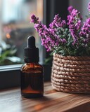 Essence bottle near vibrant purple flowers in braided pot