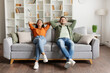 © Home-stock - Happy relaxed couple leaning on couch and holding hands behind head, enjoying comfort of their modern home. Lazy weekend, moving to new house concept