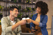 © Wavebreak Media - Clinking Diverse coworkers raising coffee cups in lounge, with laptop smartphone potted plants