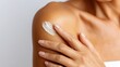 © Newleks - Young woman applying moisturizing cream on shoulder, showcasing skincare routine, protecting skin, maintaining hydration and wellness