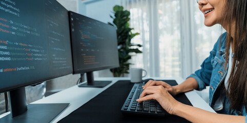 Young Asian in IT developer creating with typing online information on pc with coding program data of website application, wearing jeans shirt. surrounded by safety analysis two screens. Stratagem.