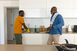 © Wavebreak Media - Washing dishes African American father and son working at kitchen sink, with green dish soap