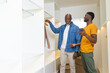 © Wavebreak Media - African American father and son organizing clothes in closet, with hanger, smartphone, copy space