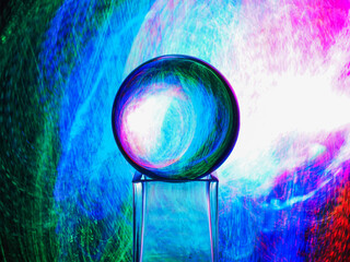 Wall Mural - a clear glass ball is sitting on a pedestal. colorful background. abstract graphic background. light