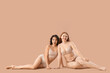 © Pixel-Shot - Young body positive women in underwear sitting on beige background