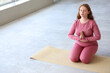 © Pixel-Shot - Sporty redhead body positive woman meditating at gym