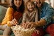 © La Famiglia - Family enjoying popcorn while watching a movie at home