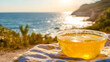 © Oktavia - Refreshing beverage on beachside picnic blanket under sunlit coastal views