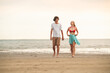 © DJ Creative Studio - Summer beach friends, two caucasian people walking on sunset beach, relaxing vacation lifestyle scene