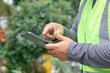 © Rakchanok - Asian overweight construction project foreman wearing white hard hat and reflective safety vest stand inspecting construction holding tablet and building plan, Inspect and explain work to workers.