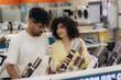 © Roman - Young Couple Shopping for Hair Styling Tools in Electronics Store