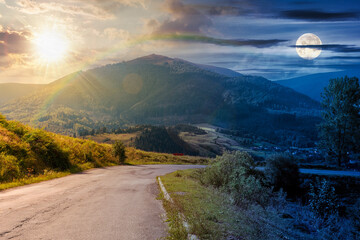 Wall Mural - mountain pass with sun and moon at twilight. road winding down the hill. scenery with valley in fron