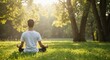© Vyatcheslav - Young man meditating peacefully in lush green park during sunlight