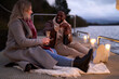 © Christina - Smiling couple in warm clothing enjoying champagne on decorated pier