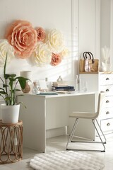 Poster - Beautiful decorative paper flowers on white wall and stylish furniture indoors