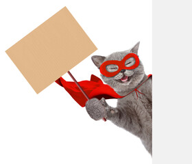Aufkleber - Happy cat wearing superhero costume looking above from behind blank white banner and showing blank cardboard on wooden stick. Isolated on white background
