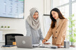 © Fahng - Teamwork, formal meeting with coworker in company office, consider agreement terms. business professional woman in hijab and collegue discuss contract details, planning cooperation, work at workplace.