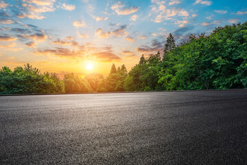 Wall Mural - empty asphalt road and green forest with beautiful sky clouds at sunset