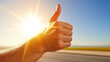 © Panupan - Hand giving thumbs up against bright sunlit background, conveying positivity and approval