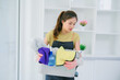 © PSG - Portrait of a charming young Asian housewife standing and smiling at the camera after cleaning the house. House hygiene and cleaning service concept.