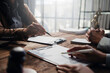 © Crystal - Lawyers and clients engaging in a detailed discussion about contract specifics during a focused meeting in a professional law office