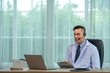 © BESTIMAGE - A doctor wearing a headset is sitting at his desk and looking at his laptop while talking.